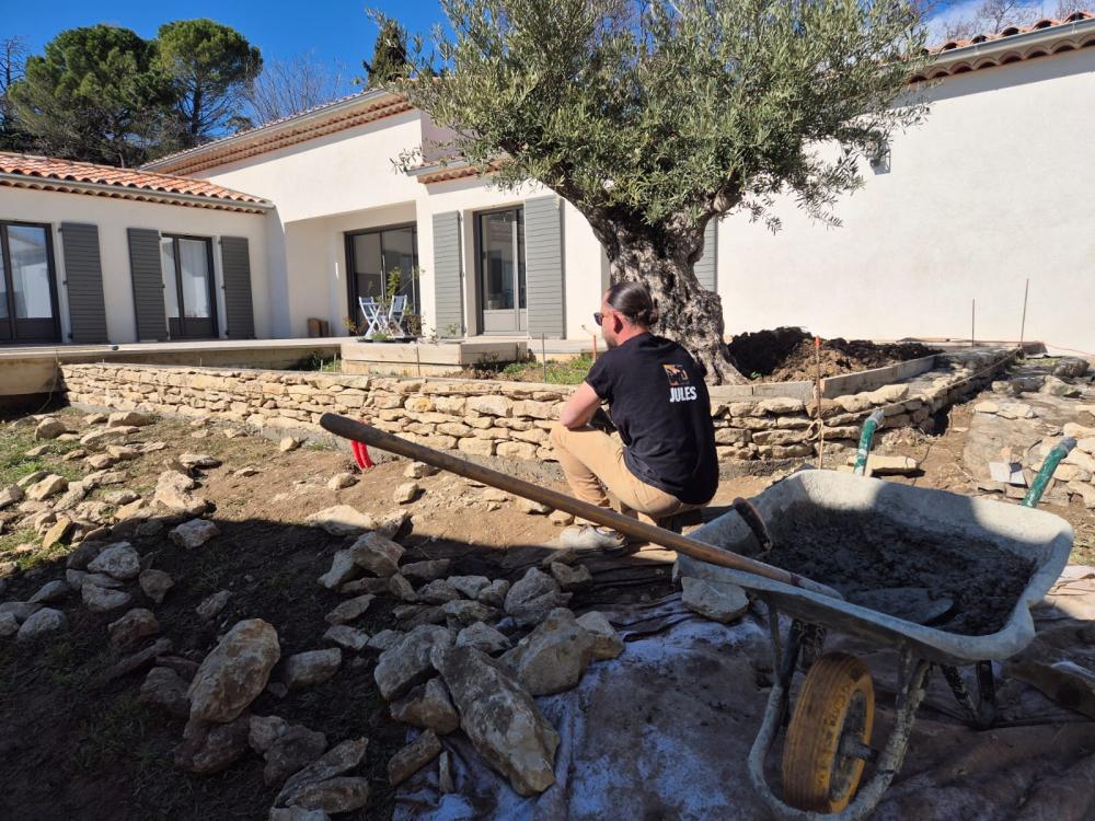 Artisan de Gonsalves Paysages construisant un mur en pierre sèche