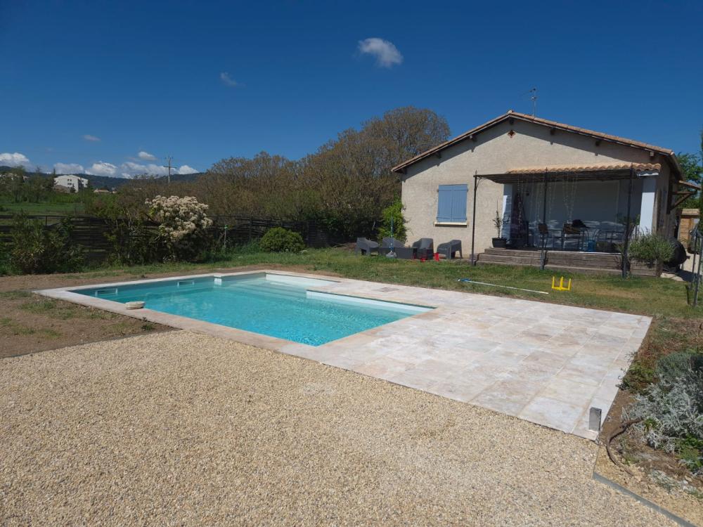 Terrasse en travertin avec bordure en gravier réalisée par Gonsalves Paysages