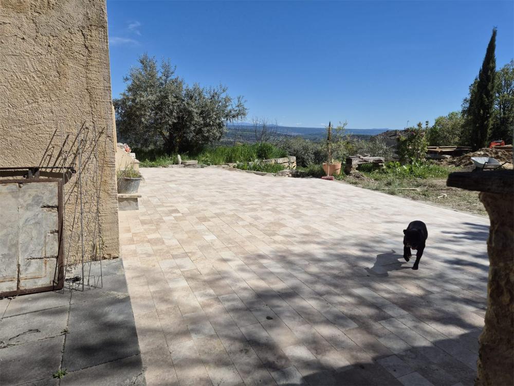 Terrasse en dallage travertin avec vue sur la vallée, réalisée par Gonsalves Paysages