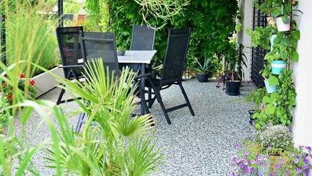 Terrasse en moquette de pierre avec salon de jardin réalisée par Gonsalves Paysages